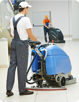 Agents d'entretien avec machine de nettoyage industriel au travail